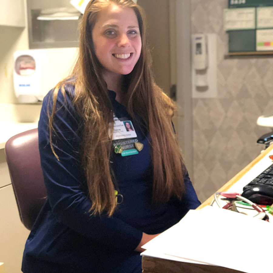 Tayrn, in scrubs, working hard and smiling