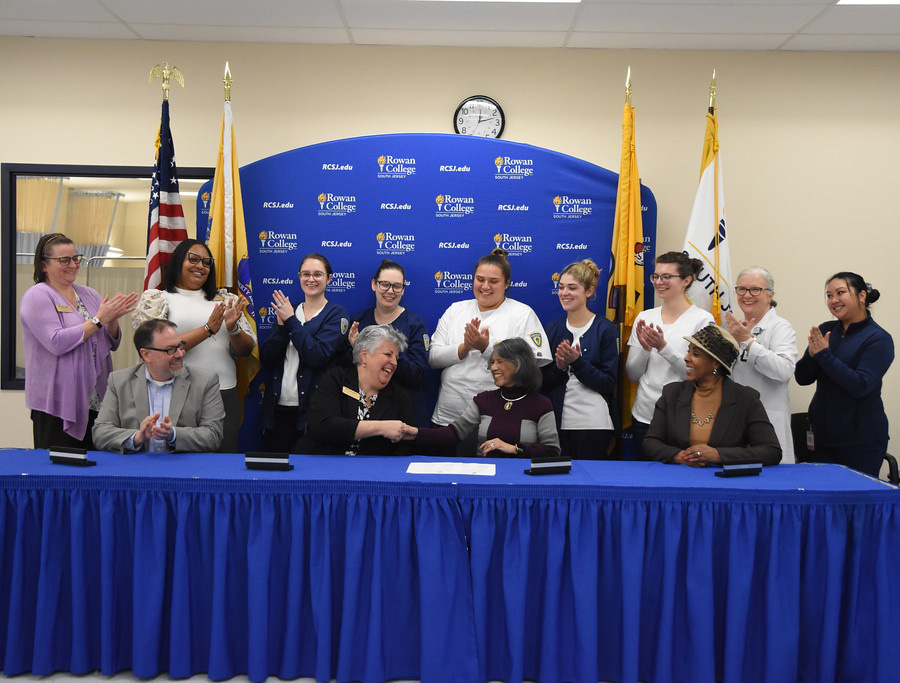 administrators signing MOU with students in background