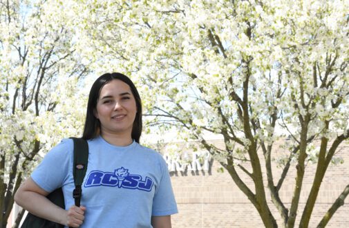 RCSJ student on campus with flowering Cherry trees