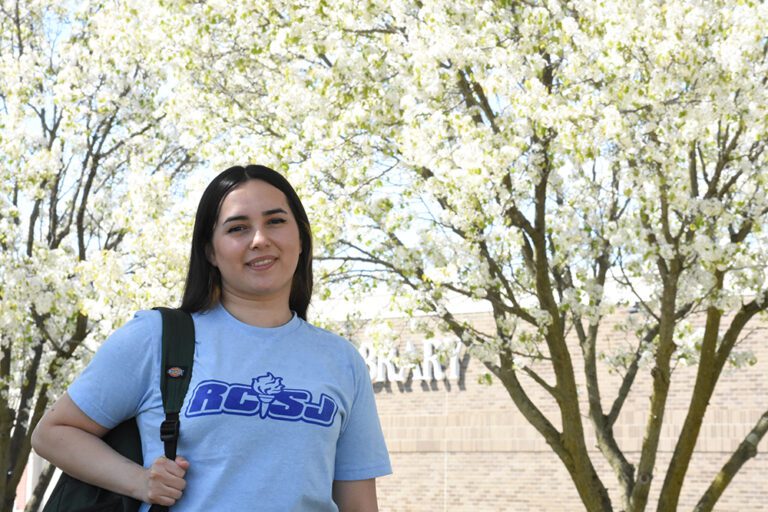 RCSJ student on campus with flowering Cherry trees