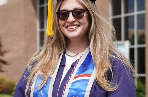 RCSJ military student poses at May 2026 graduation as part of the Commencement platform - being honored for her service to our country.